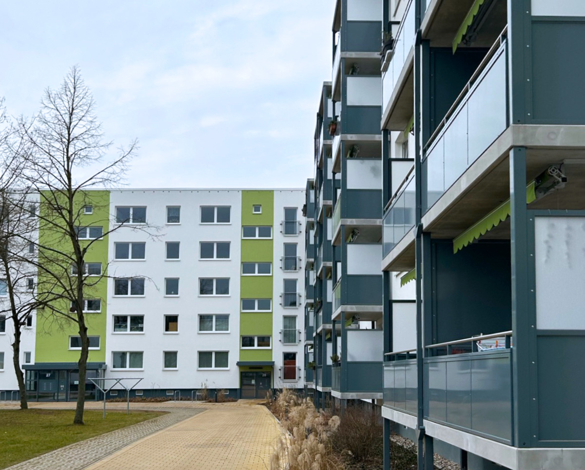 Das Foto zeigt den Innenhof im Quartier am Monumentenberg. Auf der rechten Seite sind die Balkone der Anne-Frank-Straße 21-23 zu sehen. Geradezu sieht man die Hauseingänge der Friedrich-Engels-Straße.